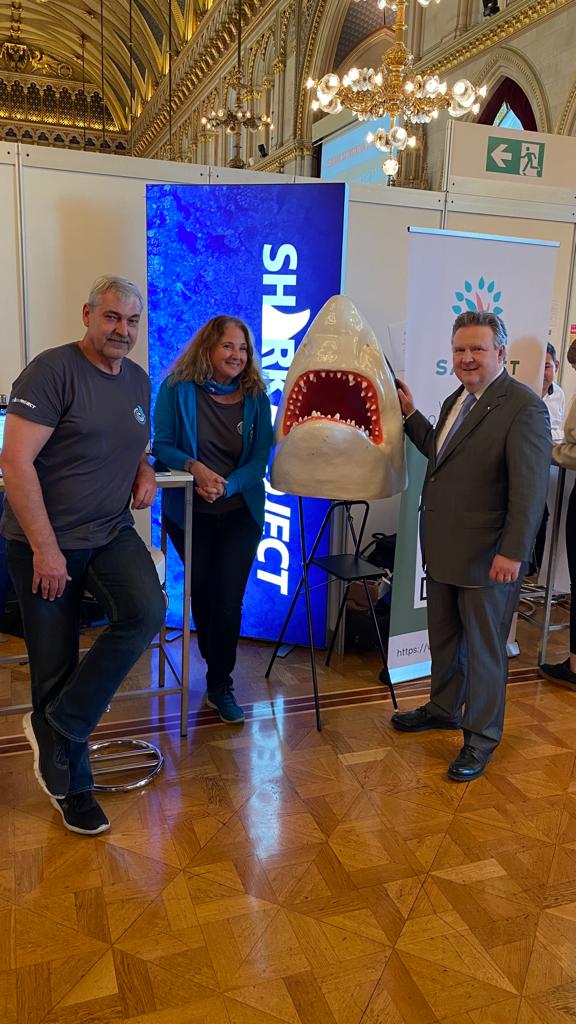 Zwei Sharkproject-Mitarbeiter gemeinsam mit Bürgermeister Dr. Michael Ludwig und einem riesigem Plastik-Haikopf