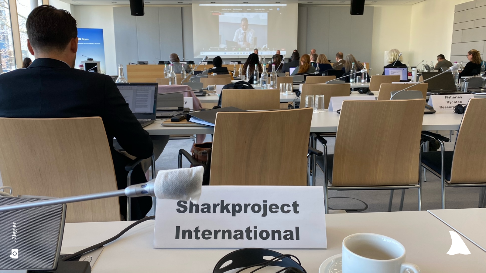 Ansicht des Vortragssaales von hinten, direkt vor der Kamera steht ein Schild mit "Sharkproject International" 