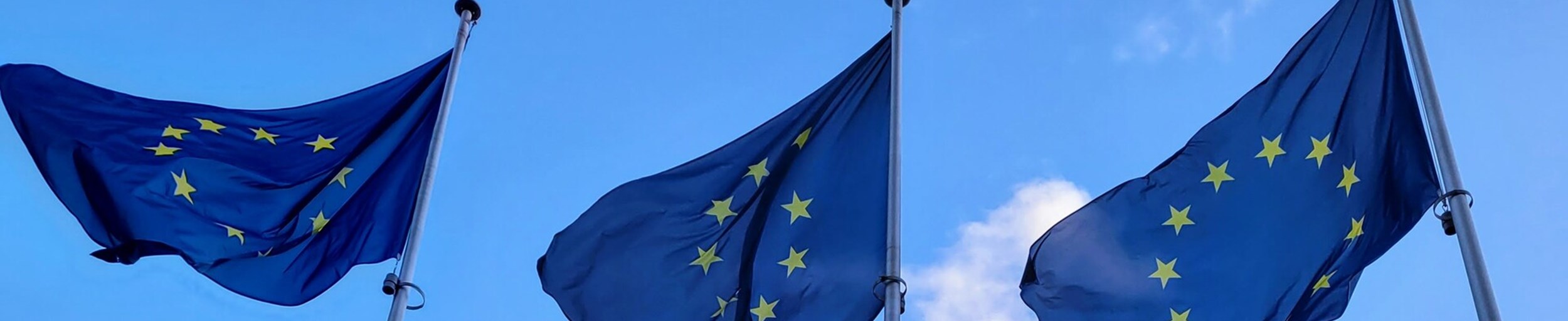 3 EU-Fahnen vor dem blauen, nahezu wolkenfreien Himmel